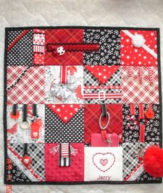 a red and black patchwork quilt with various items on it