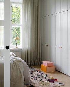 a bedroom with white closets and curtains