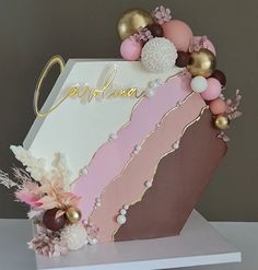 a cake decorated with pink, white and gold decorations