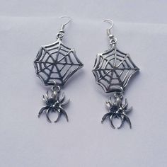 This listing is for one pair of Hanging Spider Web Dangle Earrings. Web and Spider charms measure approximately 44mm long and are attached to lead/nickel free silver toned hooks. Earrings come in a colorful organza pouch. Gift box may be purchased if sending as a gift. May also include a note to recipient if desired (no extra charge). Halloween Hypoallergenic Metal Jewelry, Spooky Silver Dangle Earrings, Silver Metal Earrings For Halloween, Nickel-free Silver Earrings For Halloween, Gothic Metal Earrings For Halloween, Gothic Nickel Free Earrings For Halloween, Gothic Nickel-free Earrings For Halloween, Gothic Nickel-free Halloween Earrings, Witchy Metal Earrings For Halloween