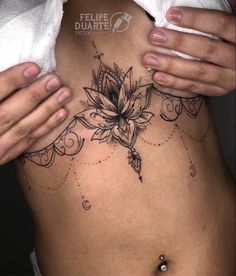 a woman's stomach with a flower tattoo on it