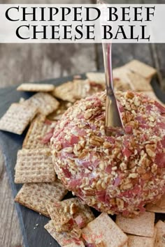 an apple covered in cheese ball sitting on top of crackers with the words, chipped beef cheese ball