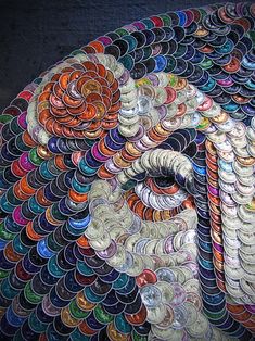 an elephant made out of many different types of buttons on a table with a black wall in the background