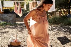 a woman in an orange dress is standing outside