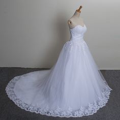 a white wedding dress on a mannequin in front of a white wall and floor