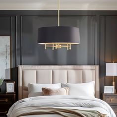 a bed with white sheets and pillows under a black shade lamp hanging from the ceiling