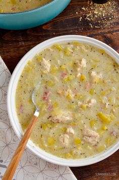 a bowl of chicken and pineapple soup with a wooden spoon in the bowl next to it