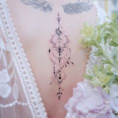 the back of a woman's neck with an angel wing tattoo on her left side