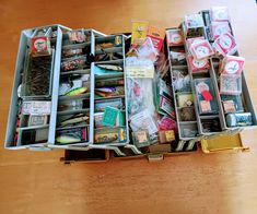 an open suitcase filled with assorted items on top of a wooden table