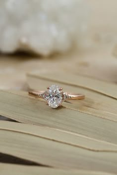 a diamond ring sitting on top of a leaf