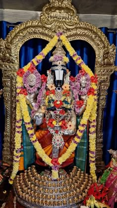 the statue is decorated with flowers and garlands