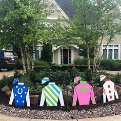 a group of people made out of paper in front of a house with trees and bushes