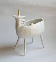 a white ceramic unicorn shaped toothbrush holder