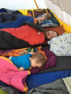 two young children sleeping on top of an inflatable tent