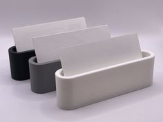 three white and black business cards in a holder