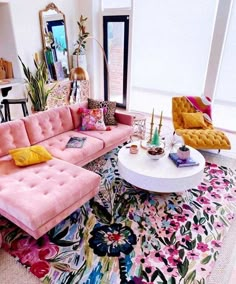 a living room filled with lots of furniture next to a large window on top of a rug