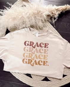 Description Experience grace and style with this essential graphic tee! Featuring a unique multi-colored "Grace" echo text across the chest, this fitted tee will be your go-to for any and all occasions. Show off your style with this one-of-a-kind cream tee! Specs 50% Cotton | 50% Polyester Unlined Hand wash cold Tumble dry low Fits true to size - model is wearing a small S (0-4), M (6-8), L (10-12) SKU#: IS-003281 Please note that all online inventory reflects inventory in store. Cream Short Sleeve T-shirt For Fall, Fall Graphic Tee With Lettering, Cream Graphic T-shirt For Fall, Pre-shrunk Cream Graphic Tee, Cream Graphic Print T-shirt For Fall, Beige Graphic Print T-shirt For Fall, Inspirational Graphic Print T-shirt For Fall, Time Graphic, Christian Sweatshirt