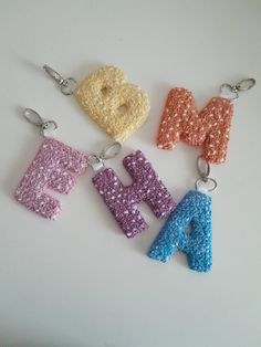 the letters are made out of tiny beads and have different colors on each letter, including blue, yellow, pink, purple, and orange