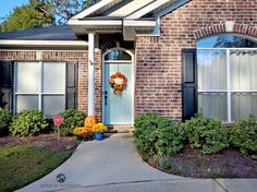 a brick house with a blue front door and wreath on it's front porch