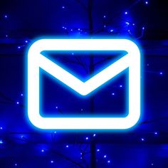 an illuminated blue email sign in front of a tree