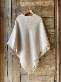 Beige lambswool poncho cape with fringes Ladies poncho cape BEIGE Pure wool hooded ladies ponchos Sand beige pure wool blanket poncho cape One size fits fashionably for most everyone, short or tall, big or small. This piece is versatile for both Men's & Women's outdoor fashion, and can be used insider in cooler winter weather to keep warm while reading on the couch. CARE: Hand-wash and hang to dry, light iron if needed, or dry clean. MEASURES: Length at the front of the neckline to the bottom is Womens Outdoor Fashion, Herringbone Blanket, Cape Cloak, Blanket Poncho, Ladies Poncho, Outdoor Fashion, Poncho Cape, Sand Beige, Winter Weather