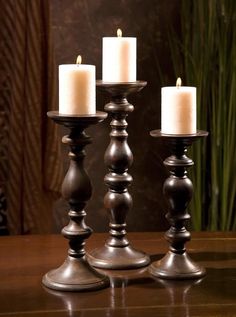 three candles sitting on top of a wooden table