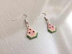 a pair of earrings with watermelon beads on them