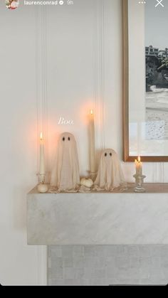 two ghost candles sitting on top of a mantle