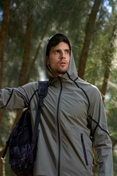 a man with a backpack is standing in the woods