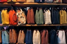 many purses are lined up on the shelves