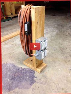 an electric box with two wires attached to it in a garage next to other equipment