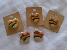 four small heart shaped buttons on top of a white cloth covered table next to each other