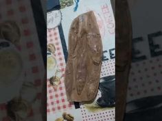 a piece of wood sitting on top of a table next to a plate and spoon