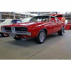 a red car parked in a garage next to other cars