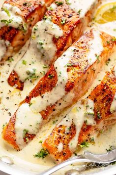 grilled salmon covered in white sauce and garnished with parmesan cheese