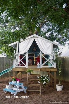 an outdoor play area with a tent and picnic table