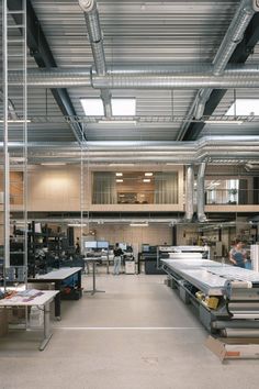 the inside of a factory with lots of tables and equipment in it's center