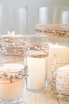 candles are sitting in glass containers on the table