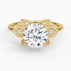 a yellow gold engagement ring with an oval cut diamond in the center and side stones