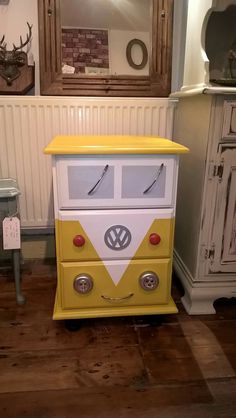 a yellow and white bus shaped dresser sitting on top of a wooden floor