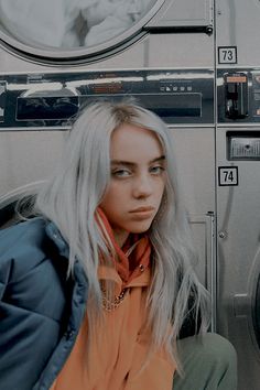 a woman sitting in front of a washing machine