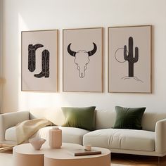 three framed pictures hang on the wall above a white couch in a modern living room