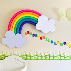 there is a wall decoration with rainbows and clouds on it