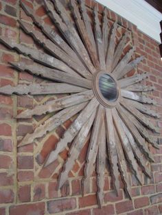 a sunburst made out of wood on the side of a brick building