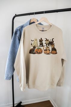 Get ready to embrace the spooky season with our Halloween Cat Sweatshirt! This cozy "Boo Sweatshirt" features adorable cats dressed in their finest Halloween costumes, including playful ghost cats, charming witches, and mischievous pumpkins. Perfect for adding a touch of festive fun to your wardrobe, this Ghost Cat Shirt is a must-have for any cat lover looking to celebrate Halloween in style. Whether you're heading to a party or simply enjoying a cozy night in, our Ghost Sweater will keep you w Casual Halloween Sweatshirt With Cat Design, Halloween Cat Print Crew Neck Sweatshirt, Casual Halloween Sweatshirt With Cat Print, Spooky Fall Tops With Cat Print, Spooky Cat Design Tops For Fall, Spooky Cat Print Tops For Fall, Halloween Cat Print Crew Neck Top, Boo Sweatshirt, Ghost Sweater