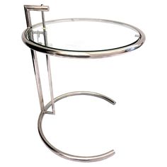 a round glass table with metal legs and a circular glass top on a white background