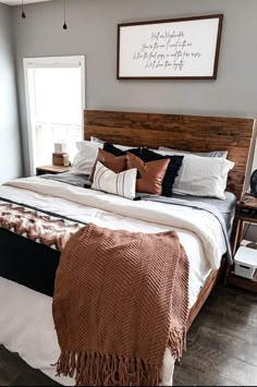 a bedroom with a large bed covered in blankets and throw pillows on top of it