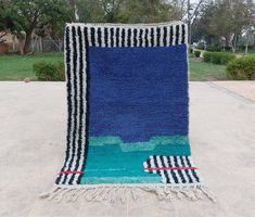 a blue rug with black and white stripes on it