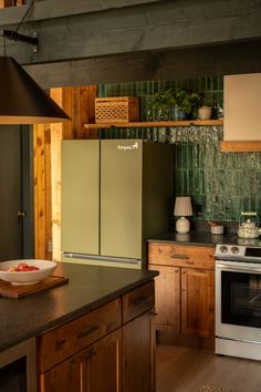 a kitchen with wooden cabinets and green tile backsplash, wood flooring and stainless steel appliances