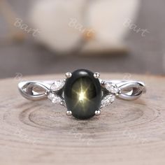 a close up of a ring with a black stone and diamonds on the side,